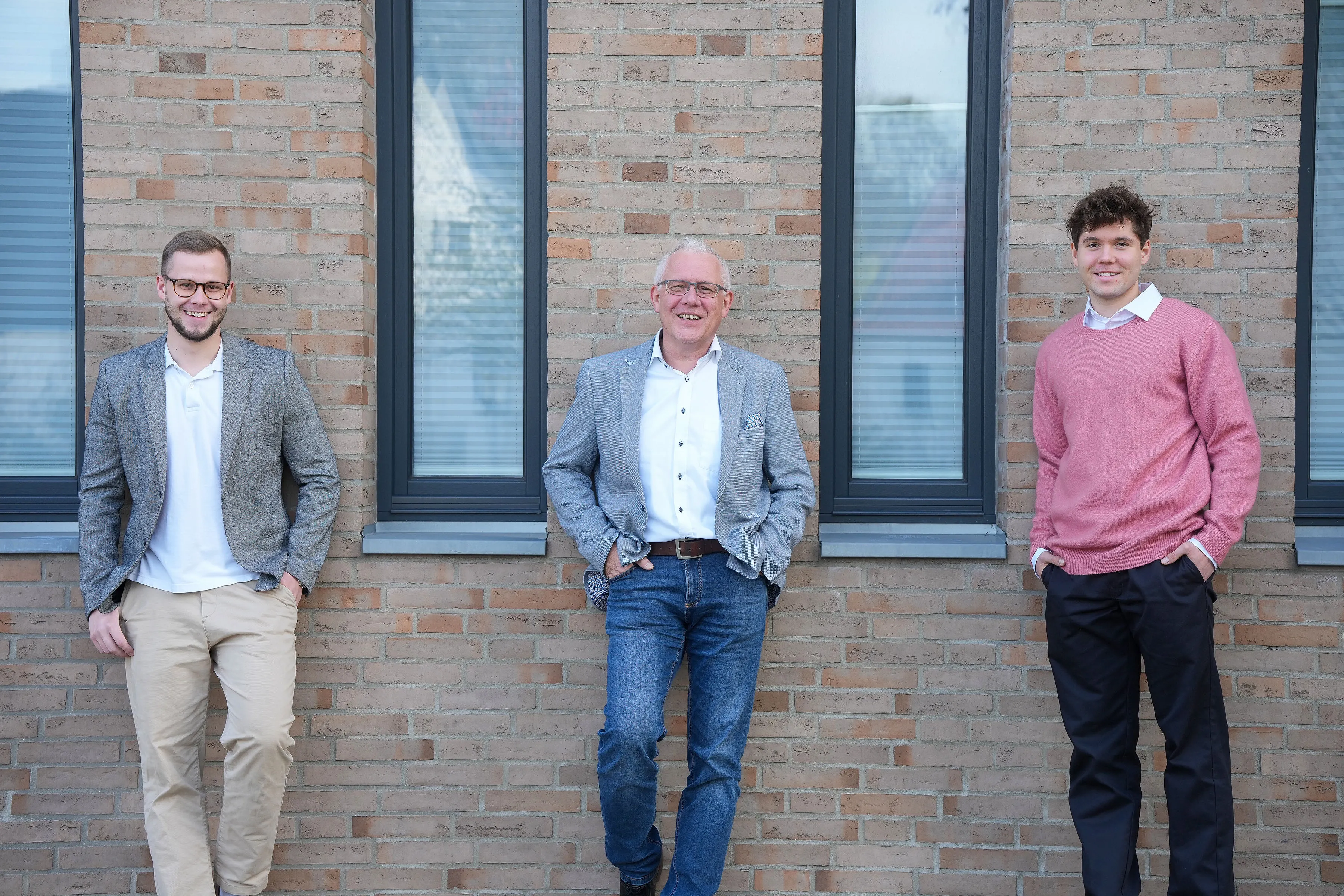 Tobias, Wolfgang und Maximilian Sellinat vor einer Klinkerfassade